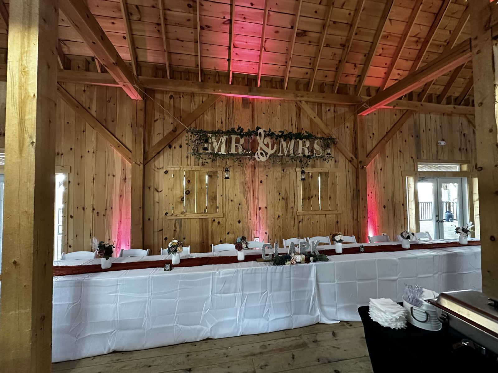 Wedding ceremony seating and décor prepared beside a rustic barn
