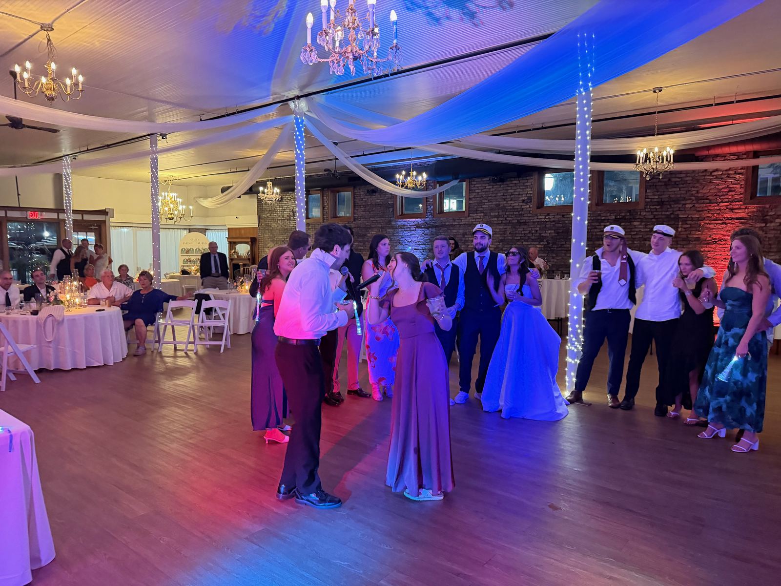 Newlyweds sharing their first dance while guests watch