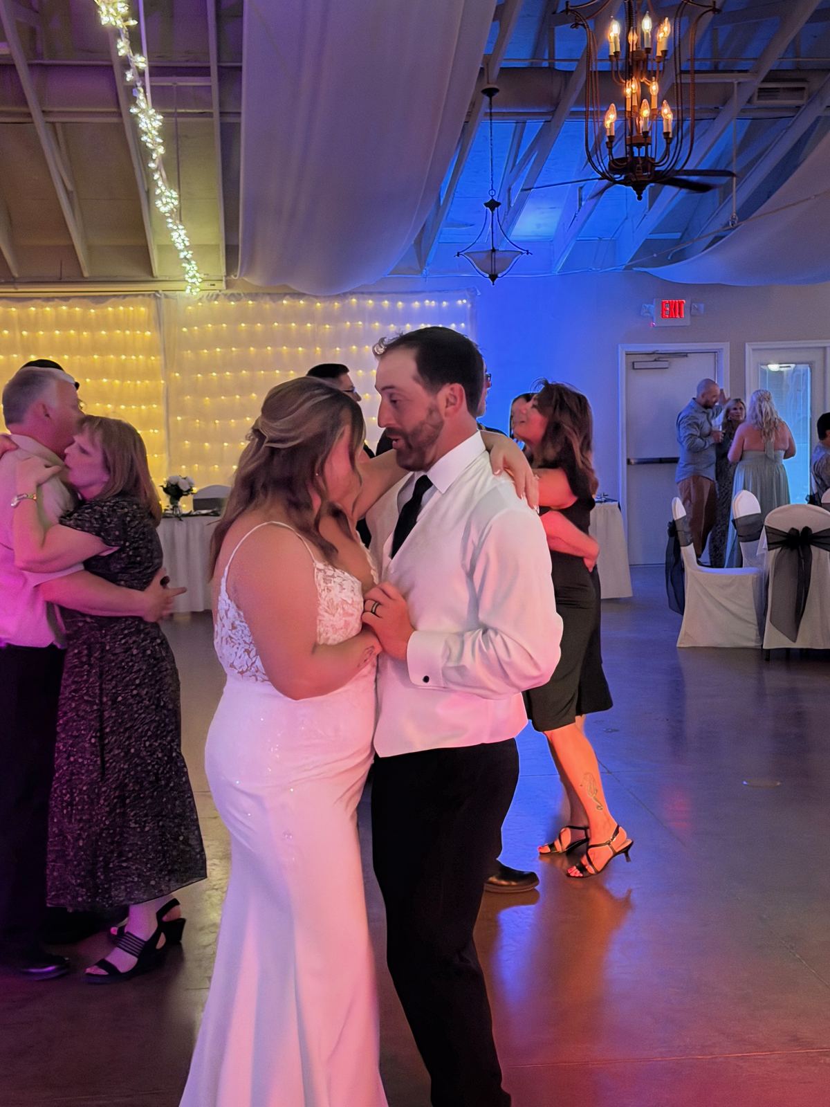 Wedding guests celebrating together beneath colorful dance-floor lighting