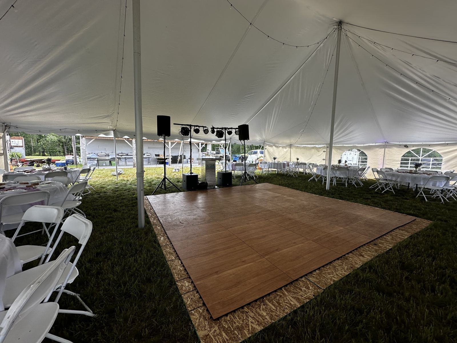Guests seated for an outdoor ceremony in a green field