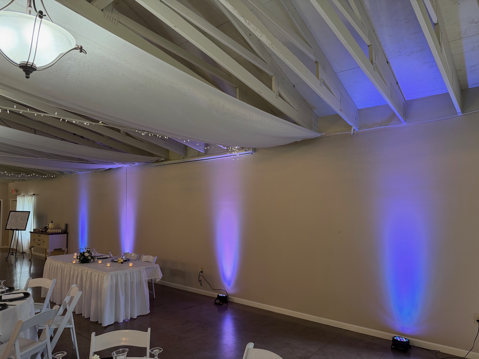 Blue uplighting washing the walls of a wedding reception