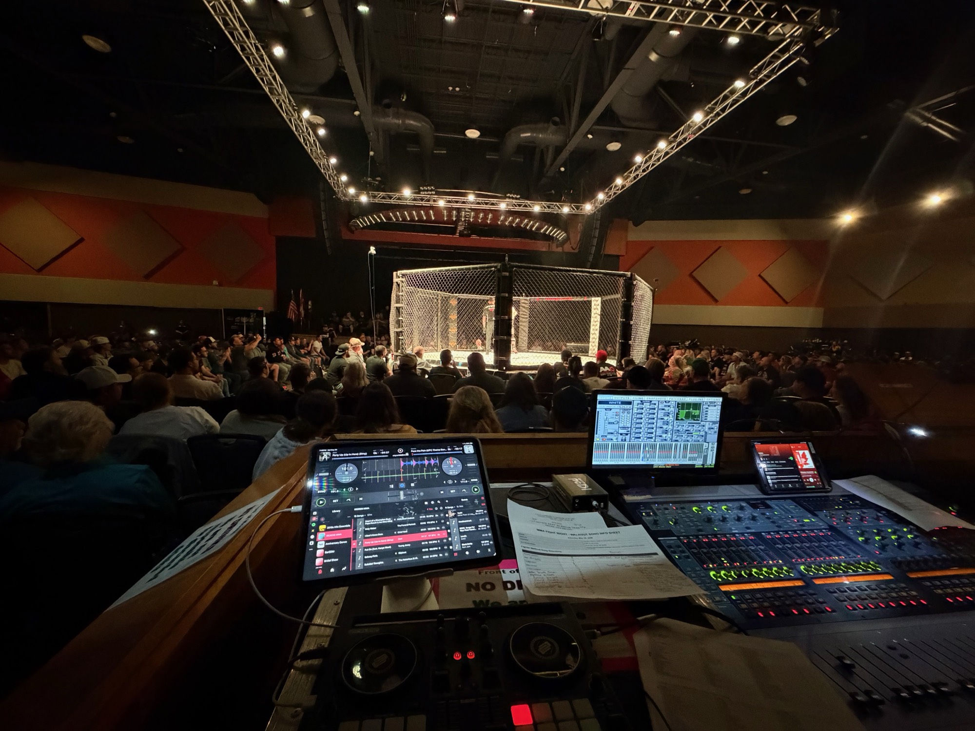 NewAge sound and music controls overlooking a packed live MMA arena event