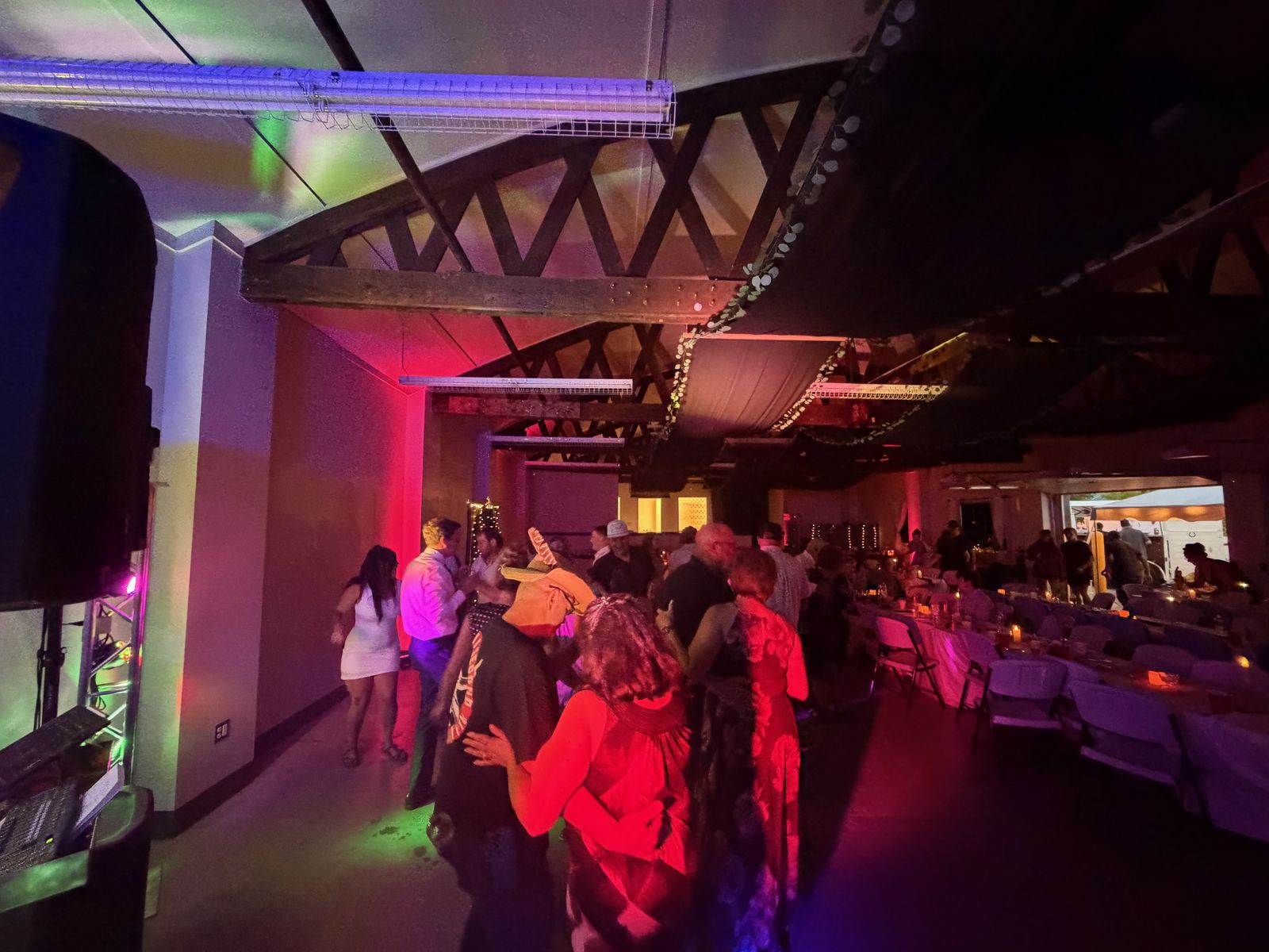 Wedding guests celebrating under colorful red and blue reception lighting