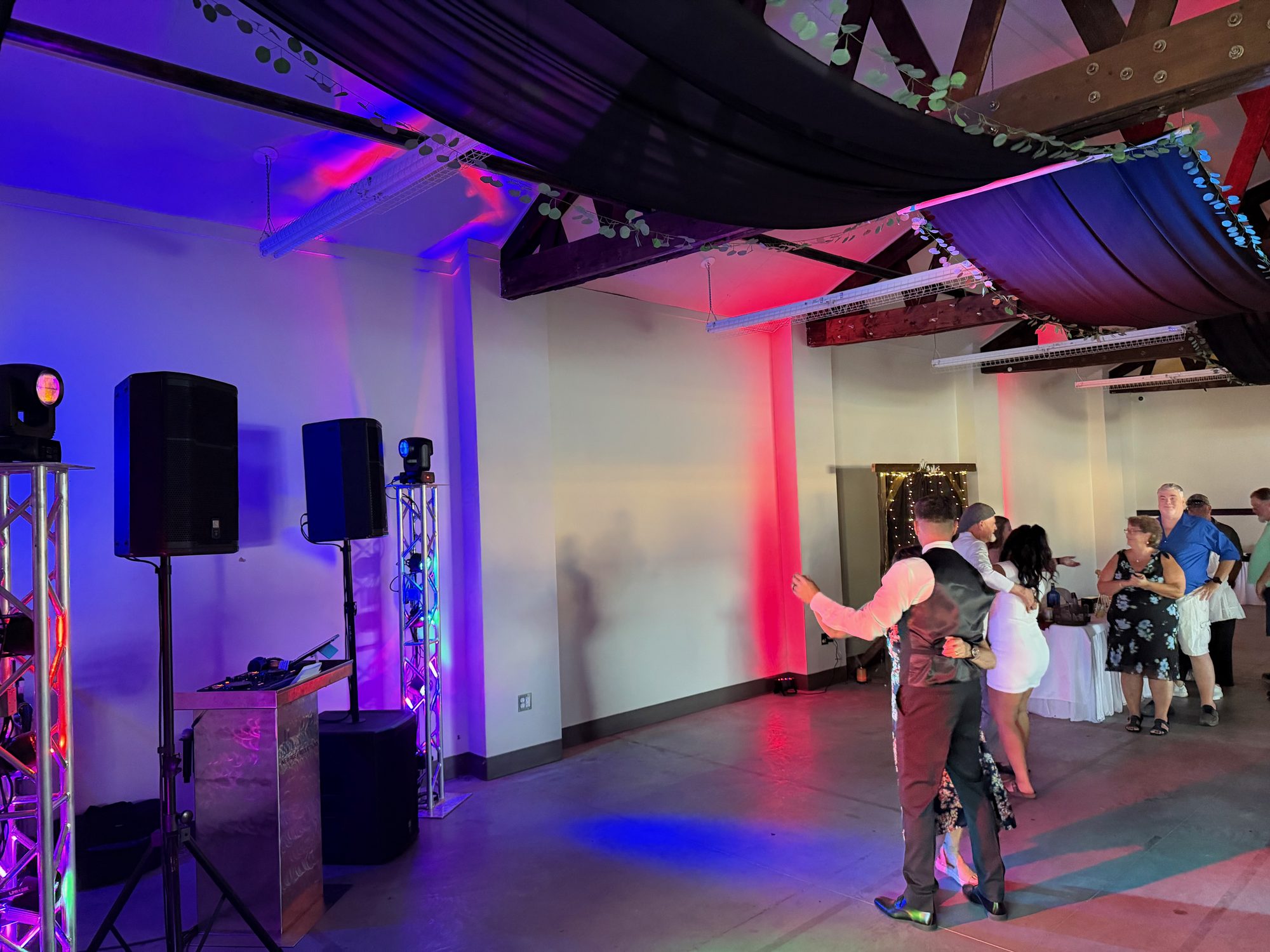 DJ booth, speakers, and lighting arranged beside a wedding dance floor