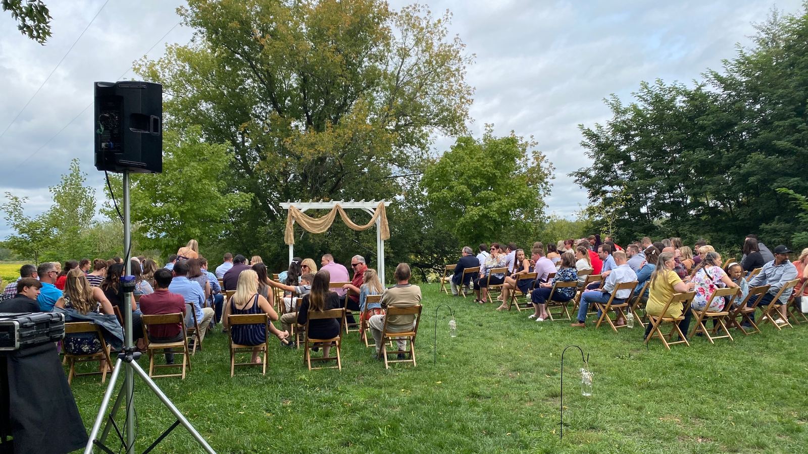 Wide view of guests gathered for an outdoor wedding ceremony