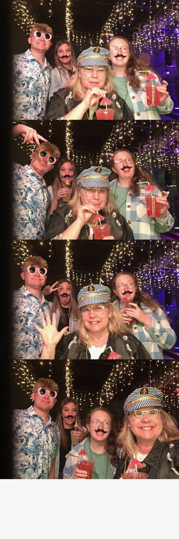 Four guests posing with playful props in a NewAge photo booth