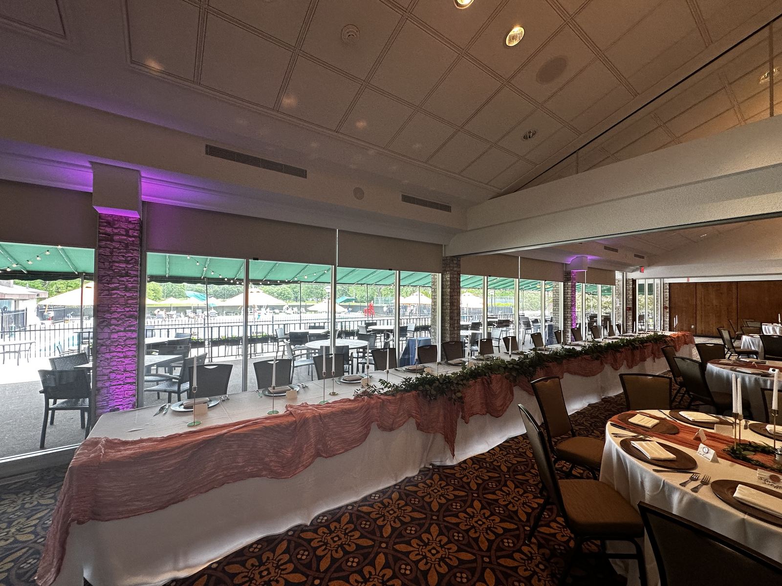 Purple uplighting transforming the walls of a wedding reception room