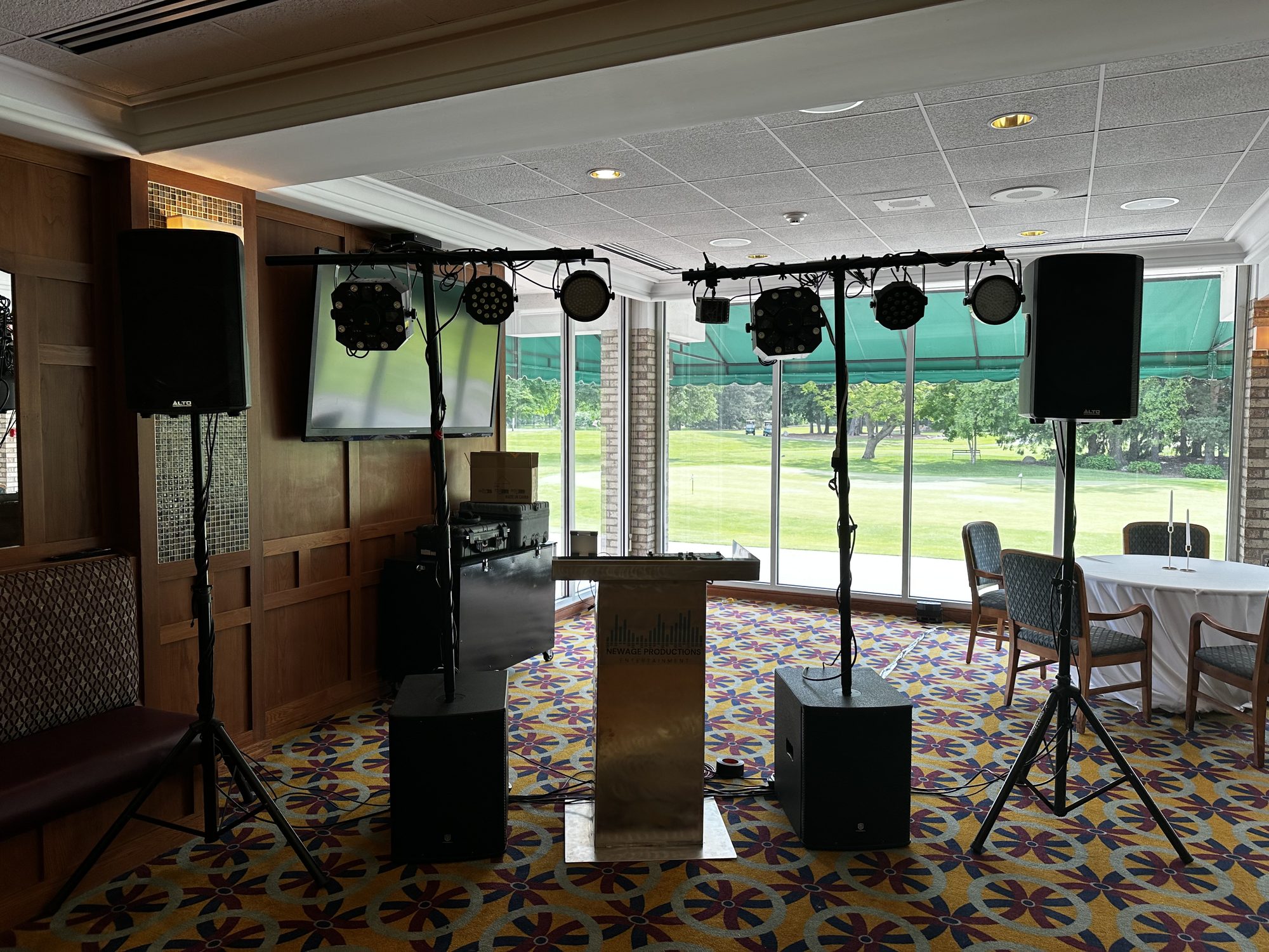 Complete DJ booth, speakers, and dance-floor lighting in a reception room