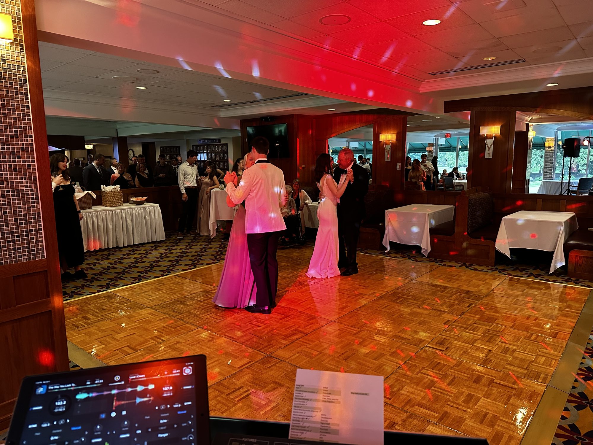 A couple sharing their first dance on a polished parquet floor