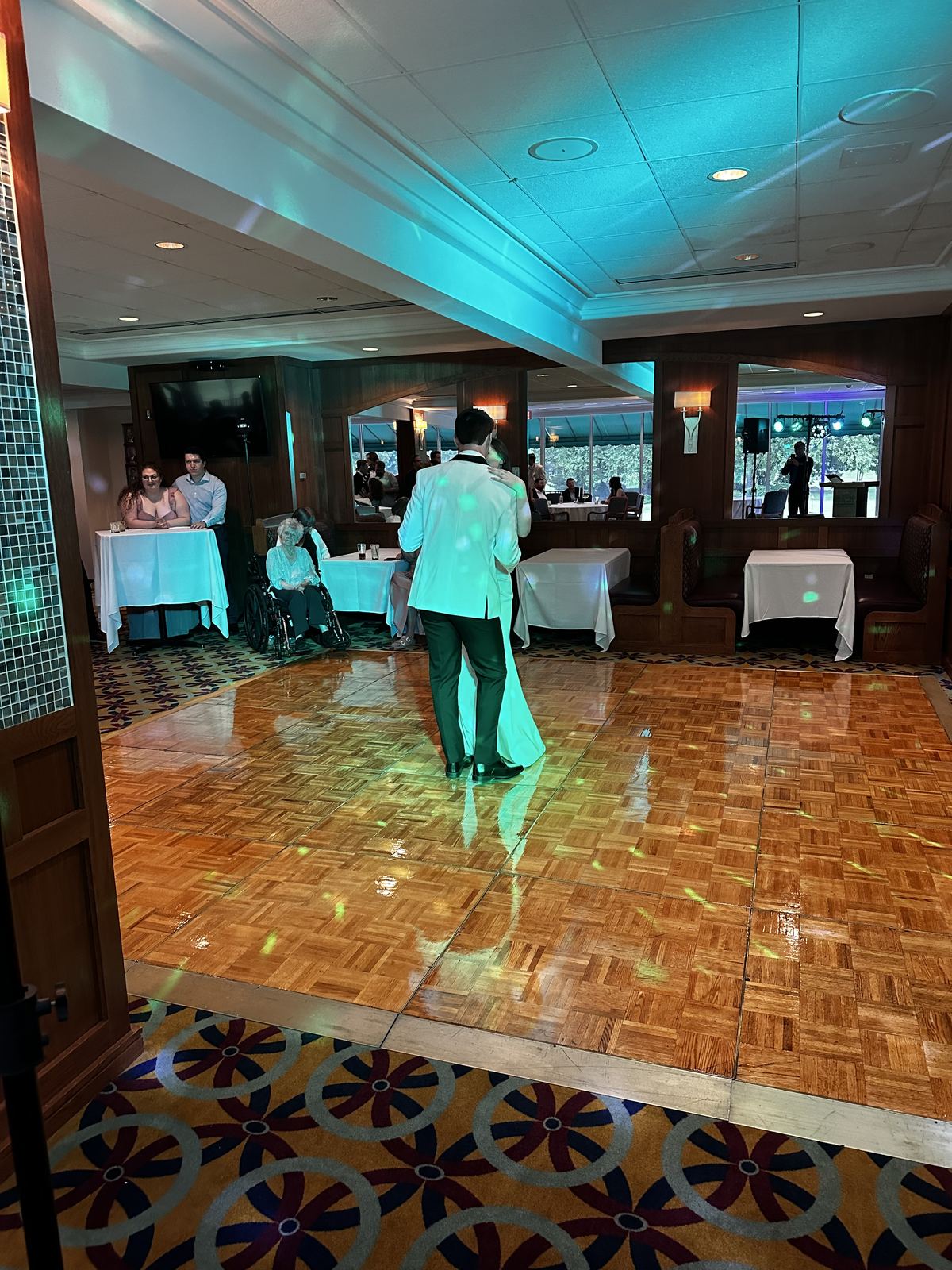 Wedding party dancing beneath blue and magenta event lighting