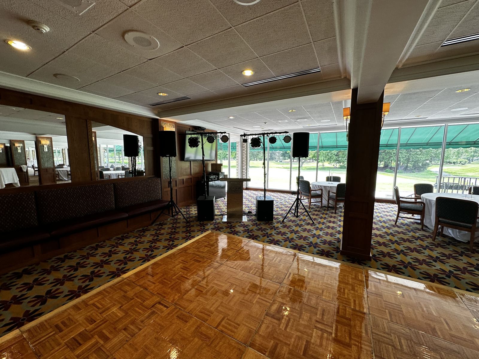 Wedding tables and dance floor arranged inside a spacious venue