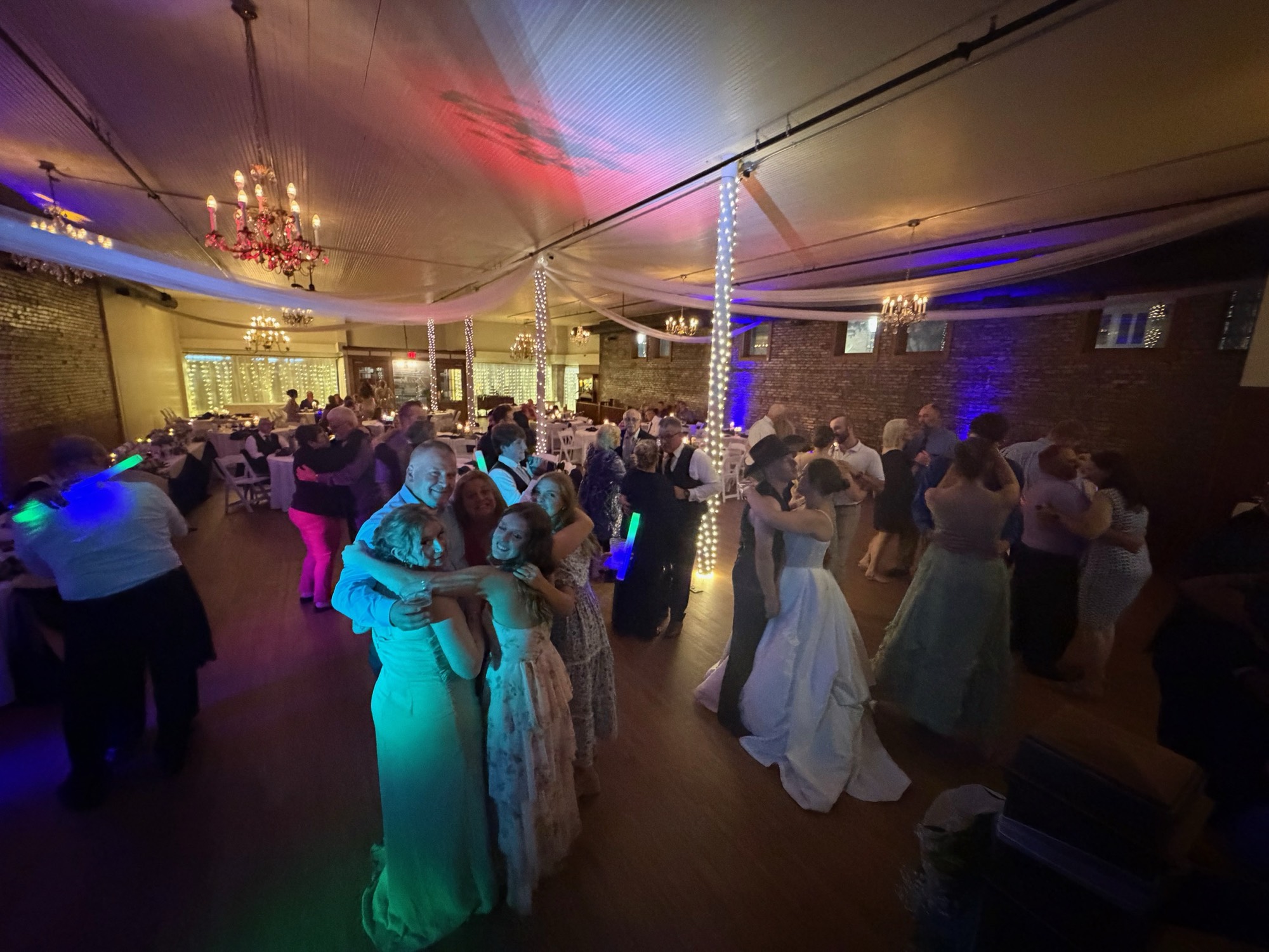A bride and her guests celebrating together on a colorful dance floor
