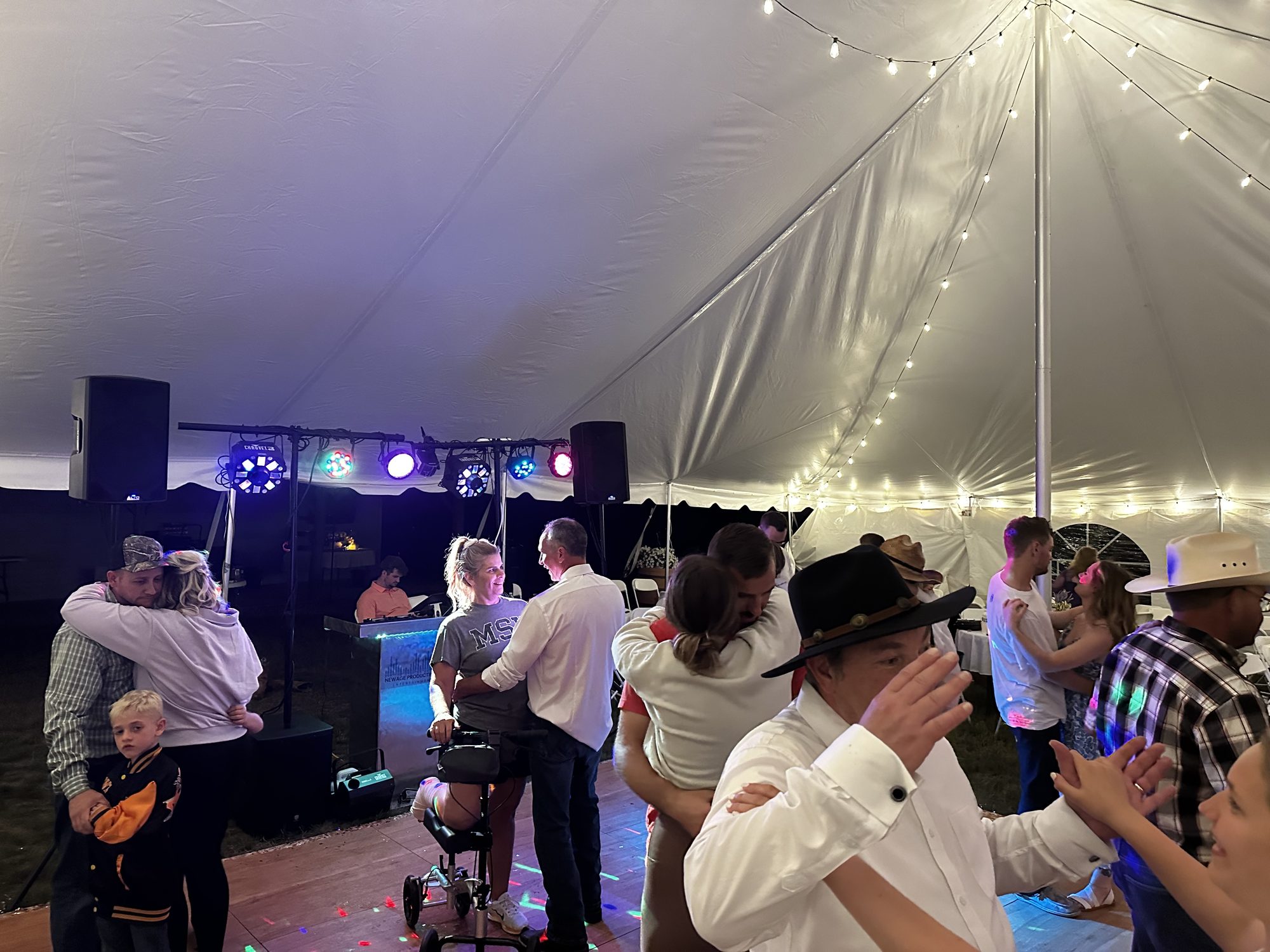 Guests celebrating together on a brightly lit tent dance floor