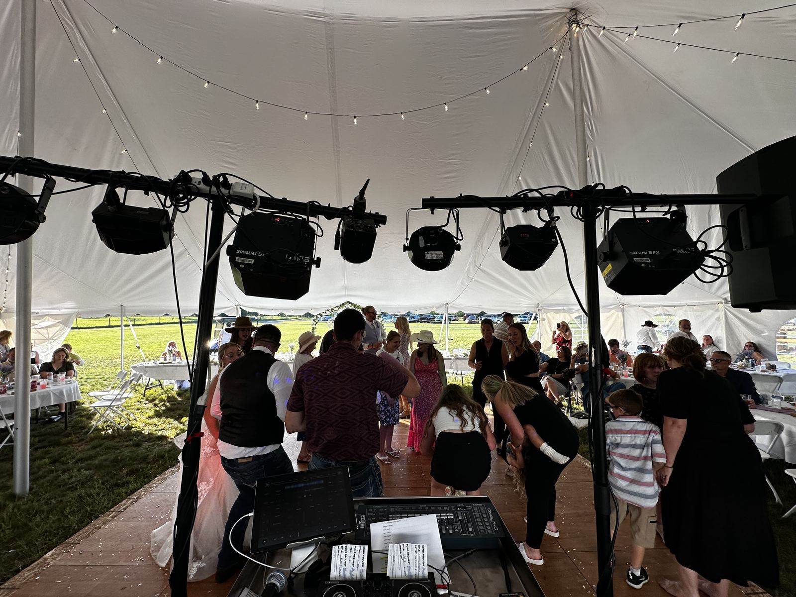 Packed tent dance floor with guests celebrating shoulder to shoulder