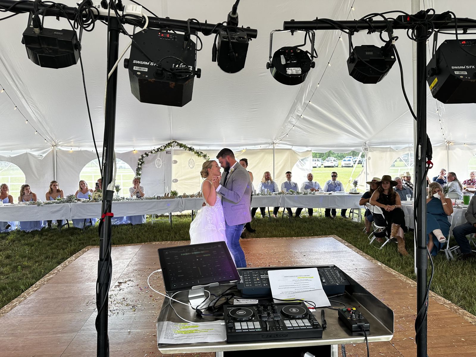 Newlyweds sharing their first dance beneath a reception tent