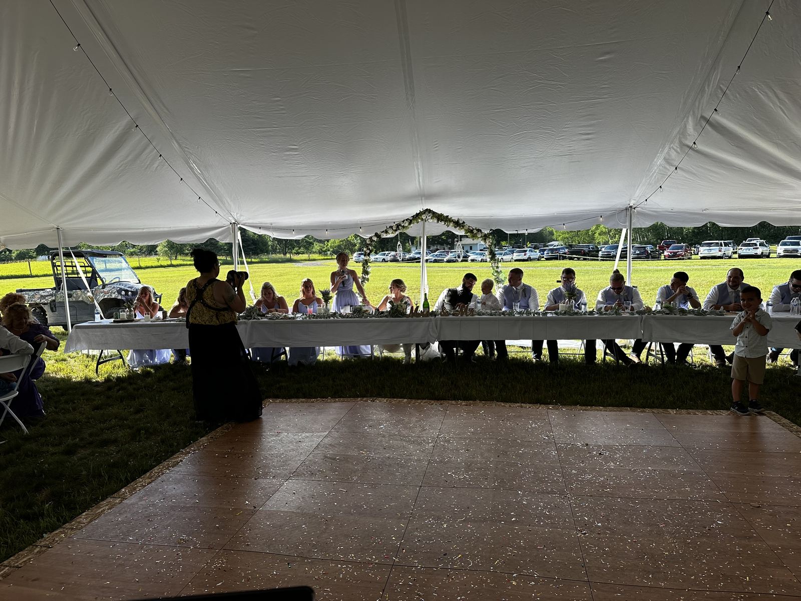 A large group joining together for a dance at a tent reception