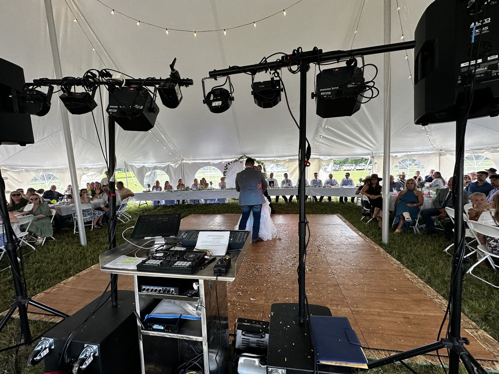 Parent dance beneath string lights at a tent wedding