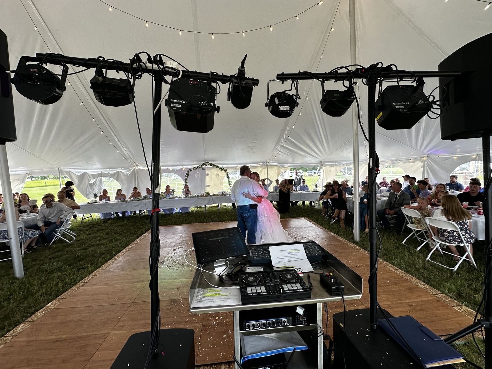 Guests celebrating together beneath a white reception tent