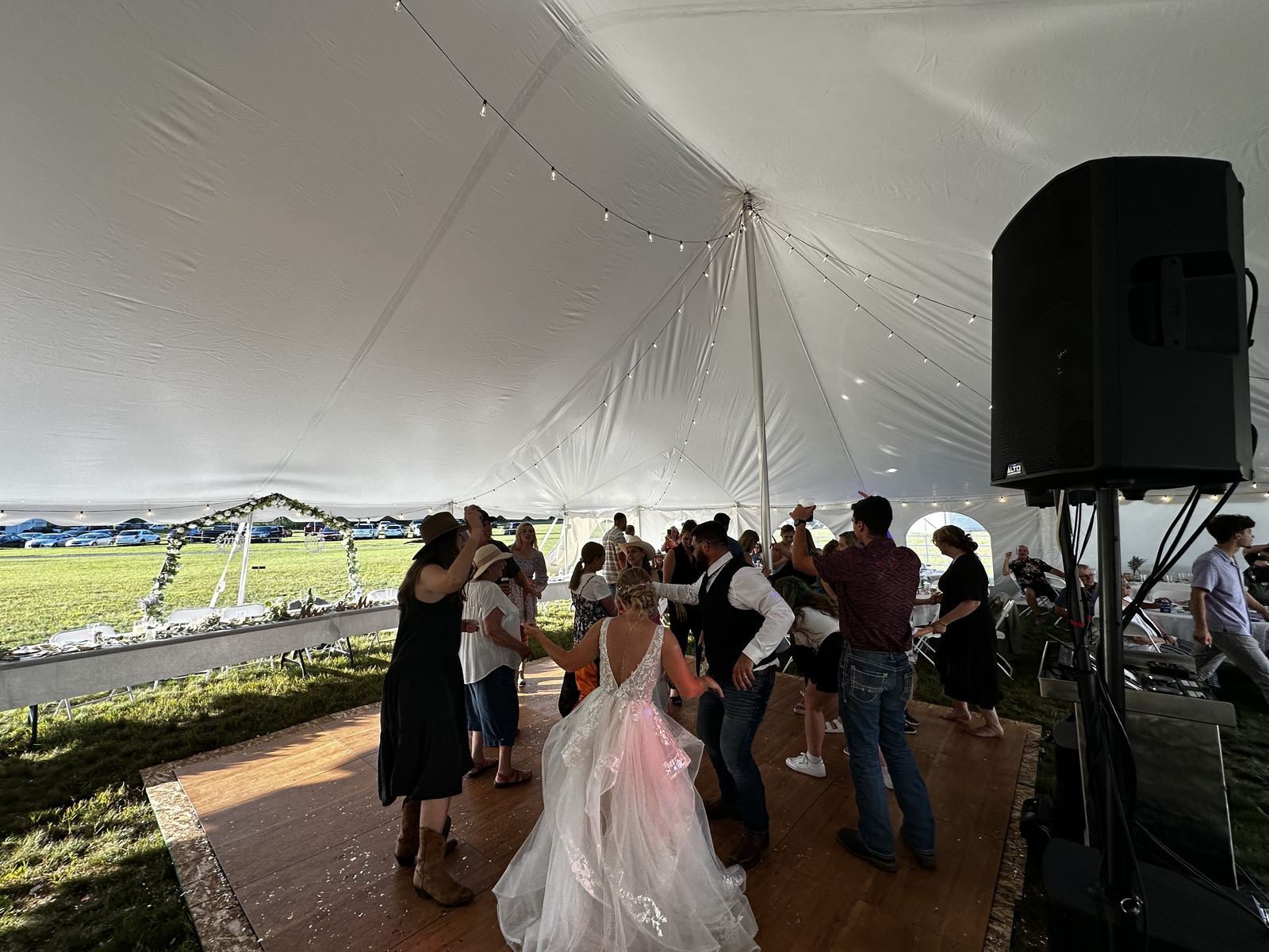 Wedding guests filling the dance floor beneath tent lights