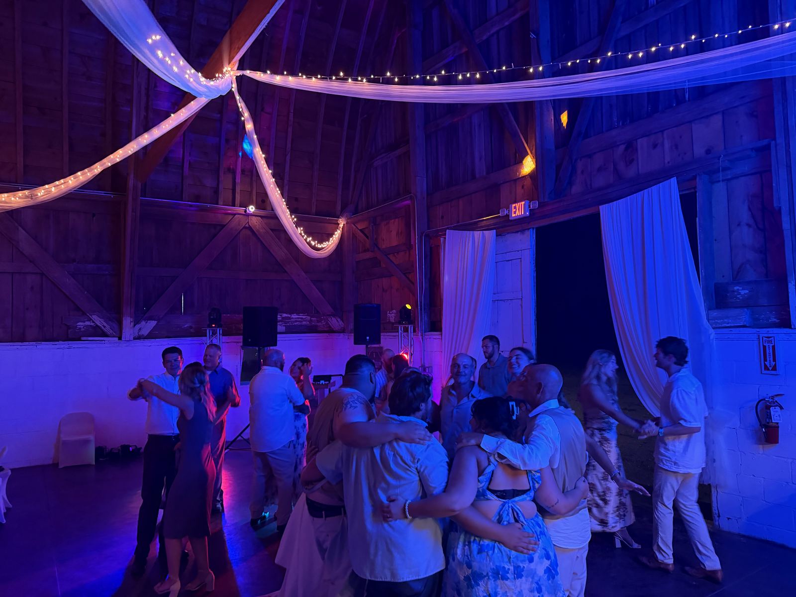 Wedding guests filling a barn dance floor for a group dance