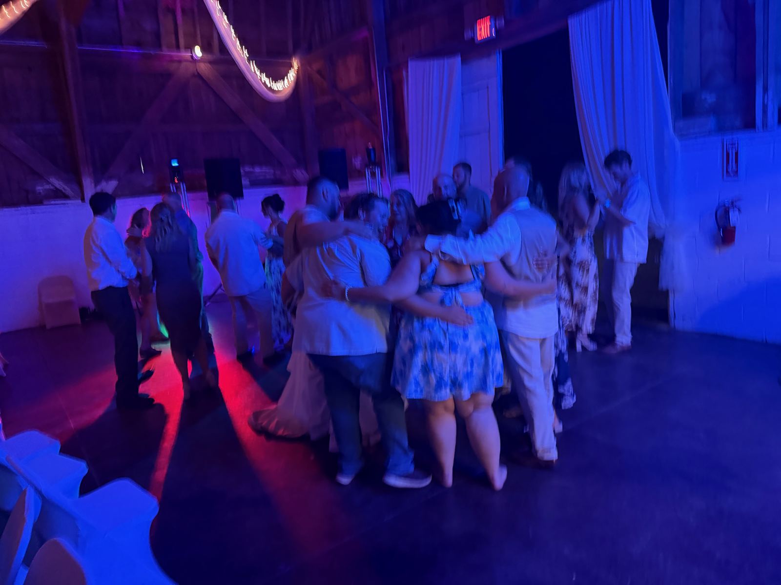Guests dancing together at a rustic barn wedding reception
