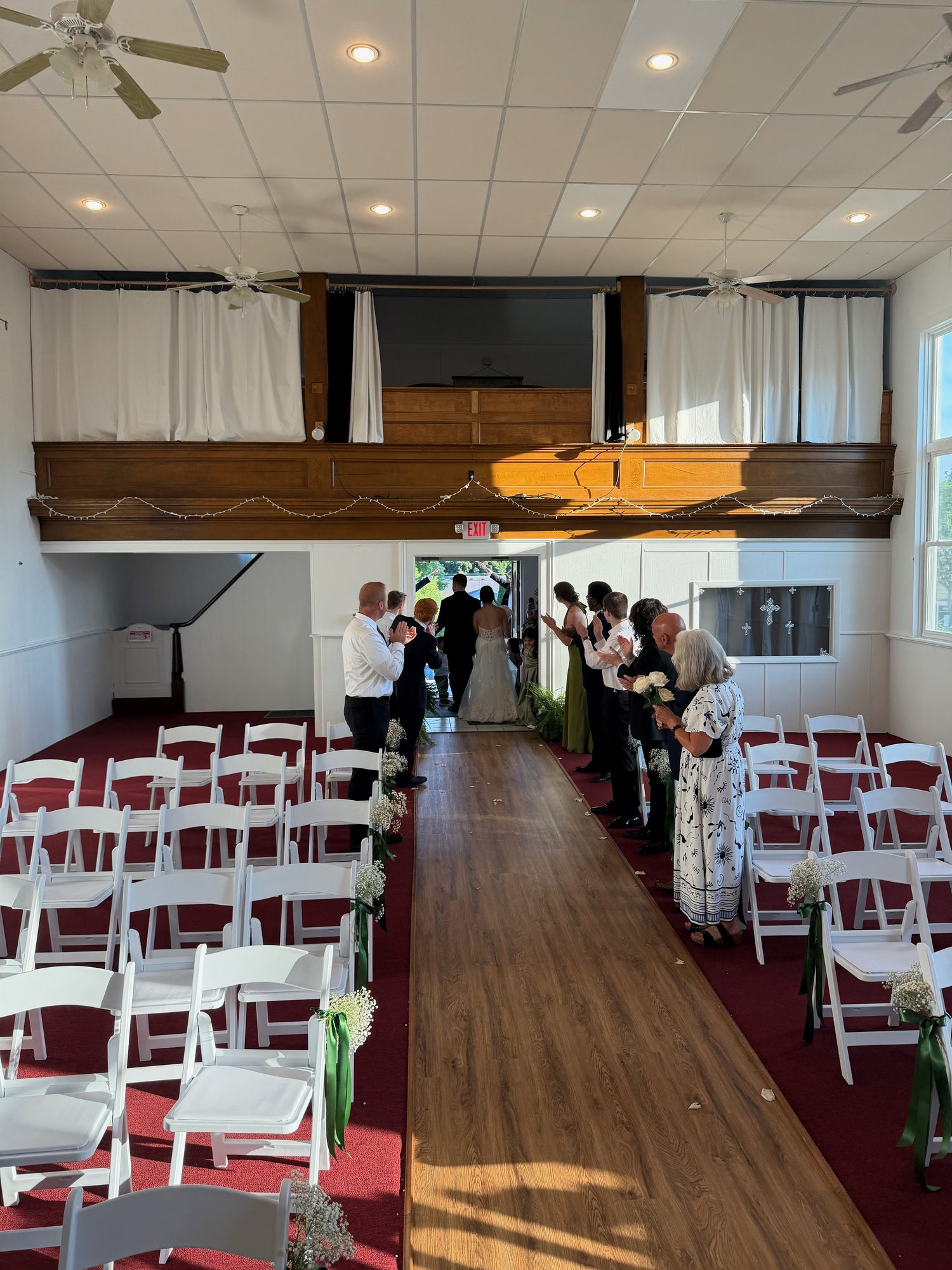 A wedding party walking through an indoor ceremony aisle