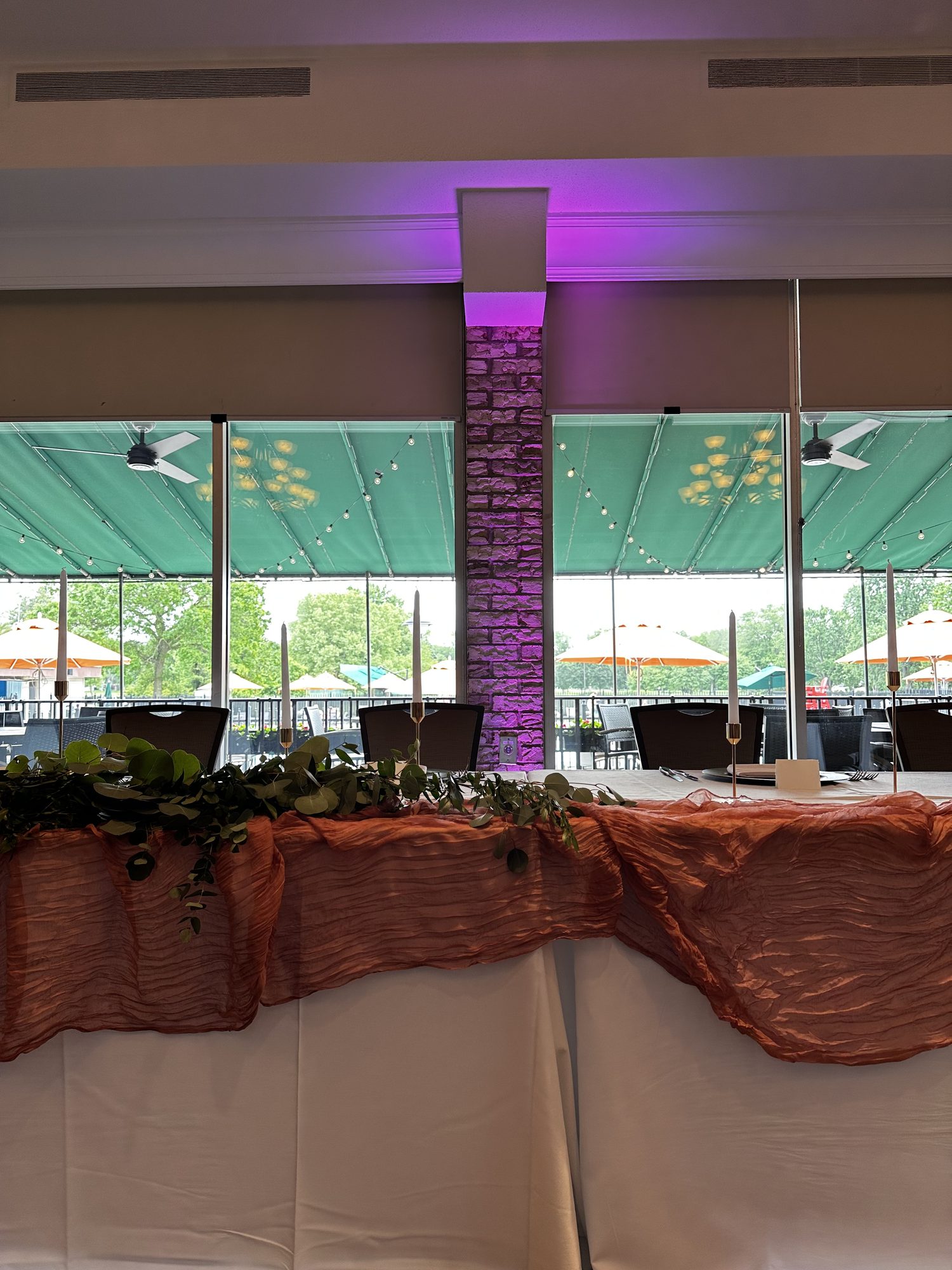 Reception head table framed by purple uplighting