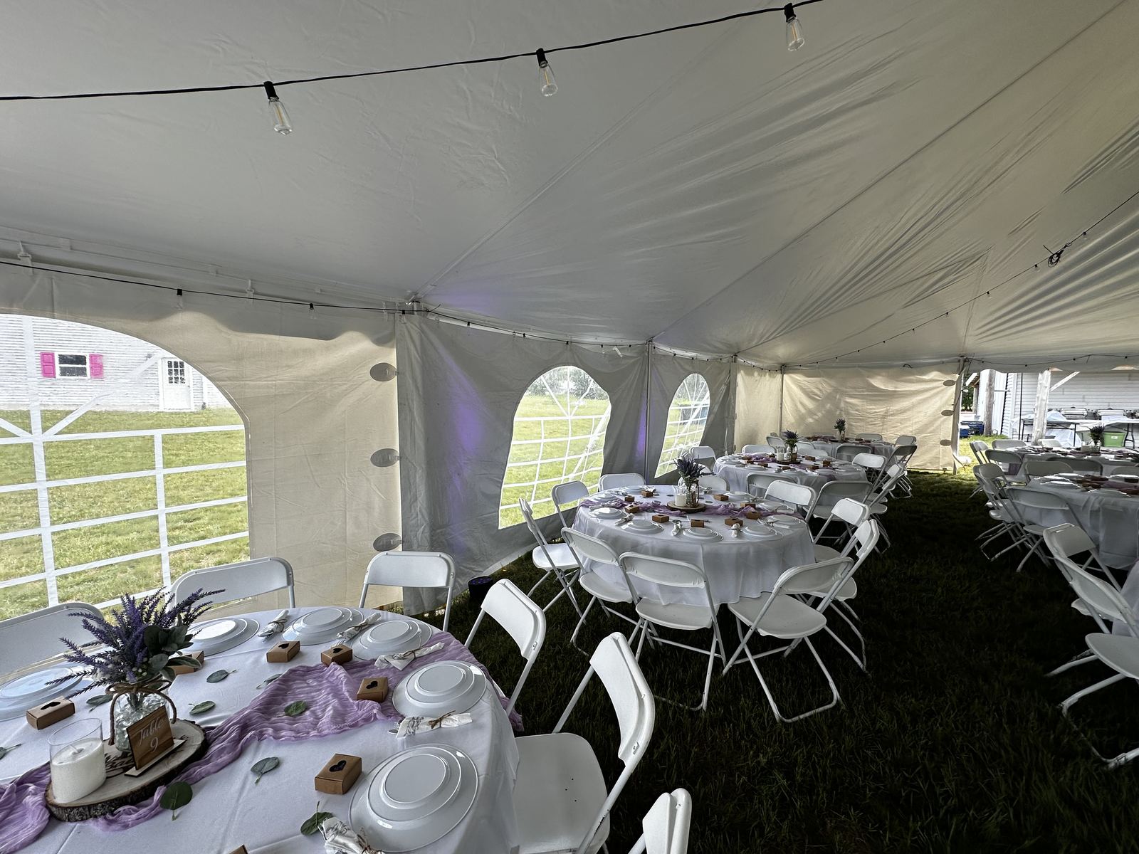 Wedding ceremony taking place beside a waterfront reception tent