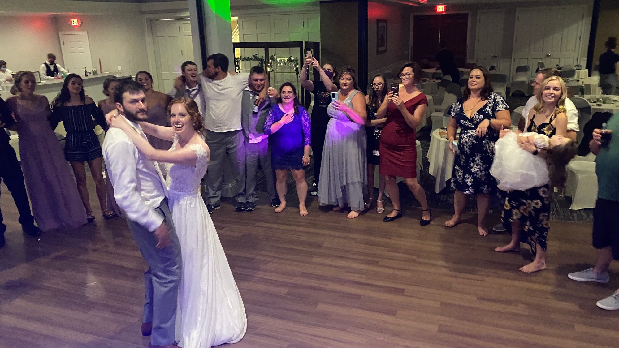 Newlyweds dancing in the center of a circle of cheering guests