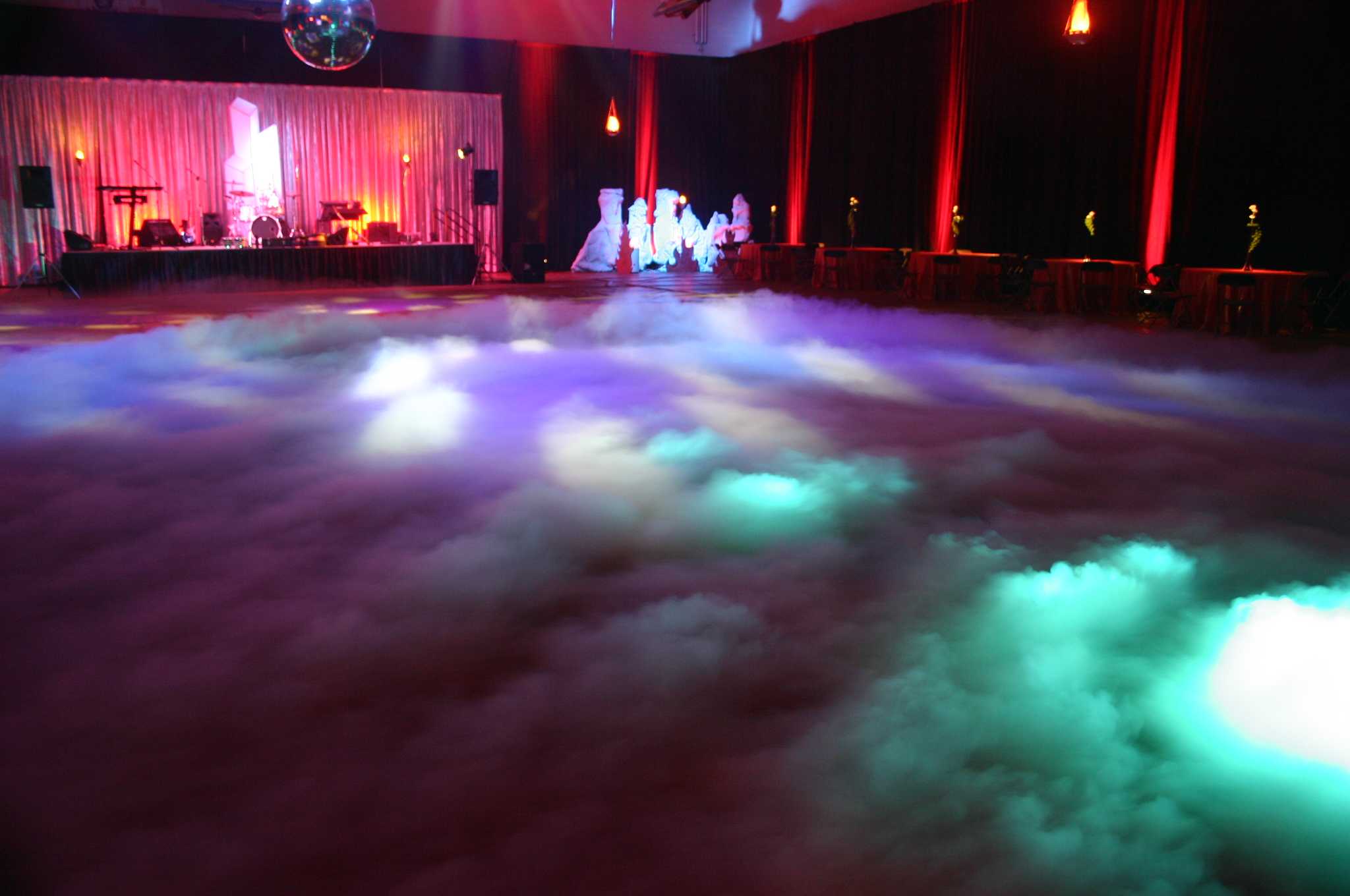 Low fog and colored lighting spread across a dance floor