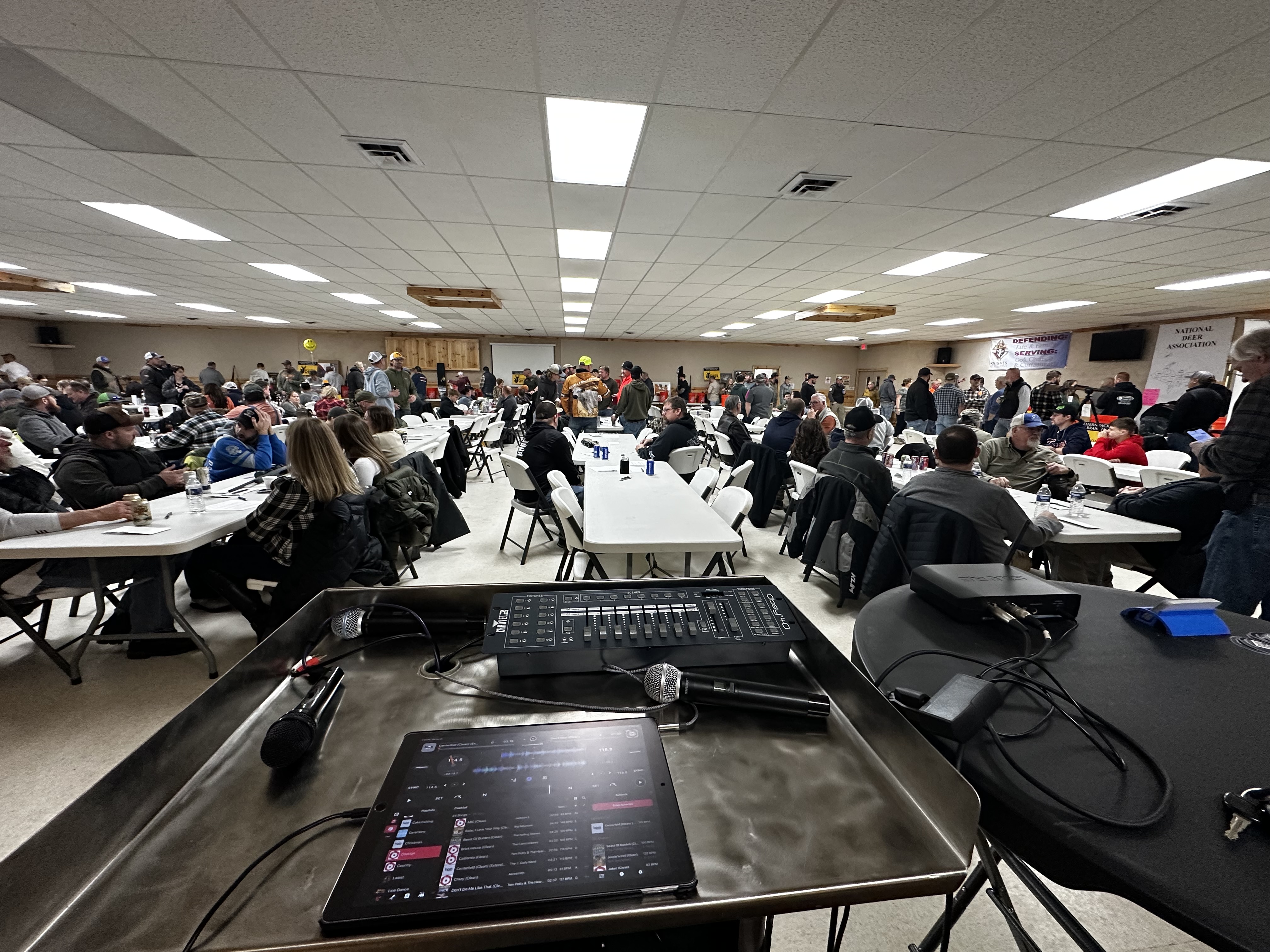 Large company gathering with a DJ station in front